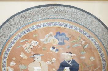A 20th century Chinese framed embroidered figurative silk circular panel with a brocade border